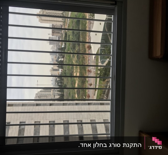 חלון עם סורגים מול נוף עירוני